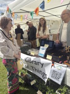 The mayor of Leamington talking across a decorated table to two volunteers.